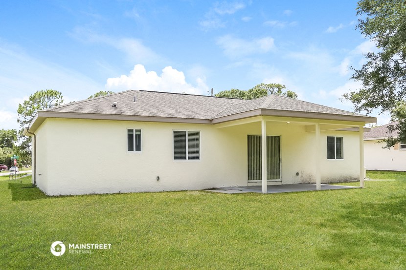 a small white house with green grass and a yard
