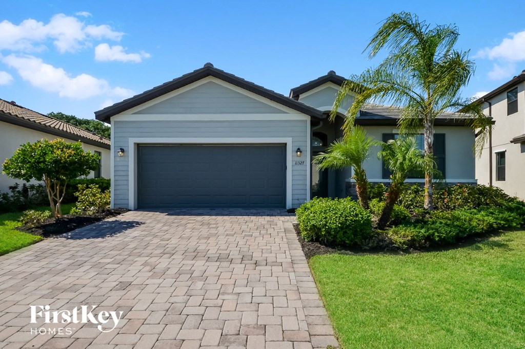 A house with a garage and a driveway in front of it.