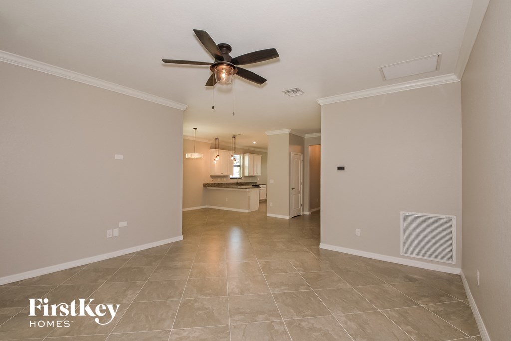 A spacious room with a ceiling fan and tiled flooring.