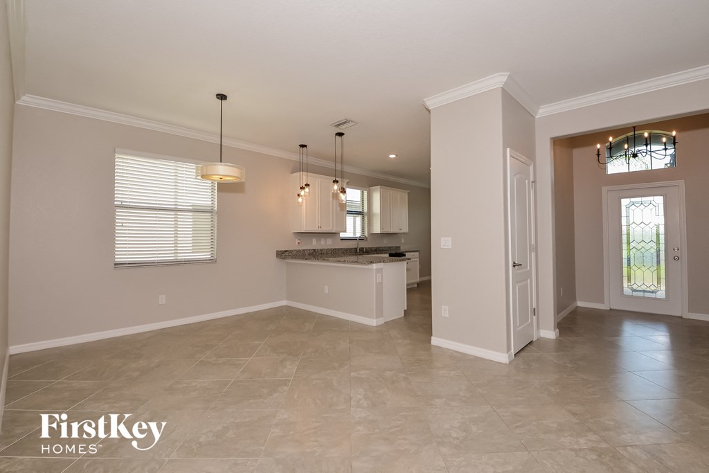 A spacious kitchen area with a bar and pendant lights.