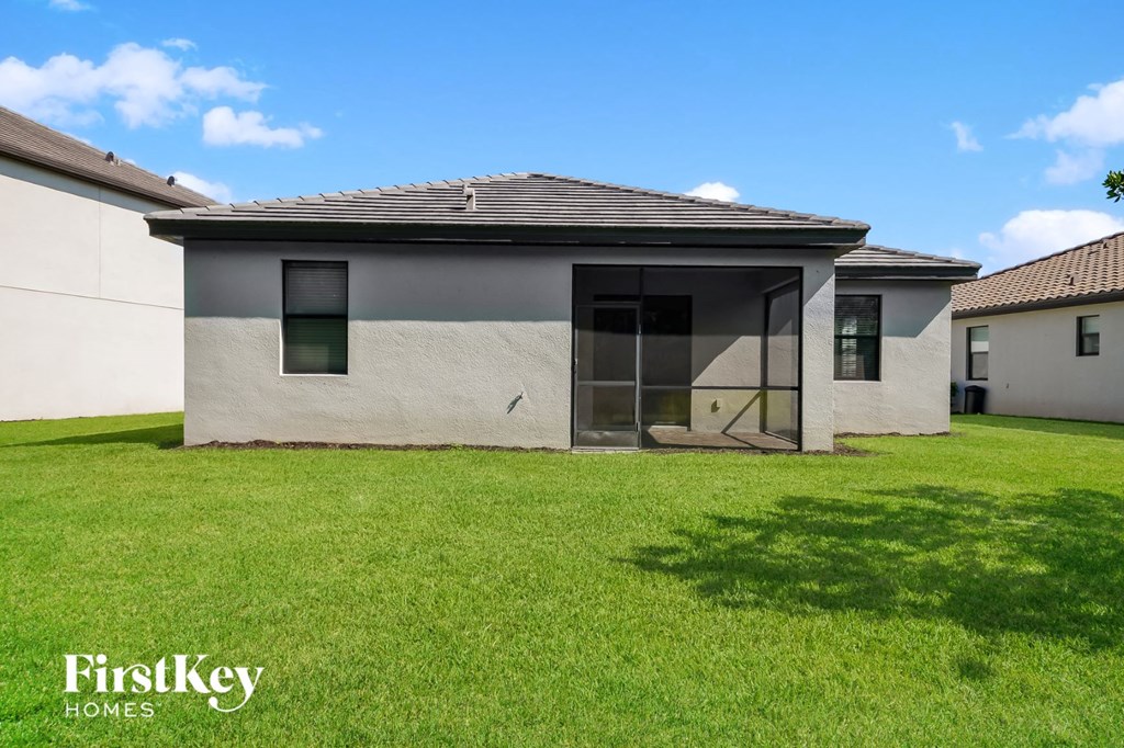 A modern house with a grey exterior and a large lawn in front.