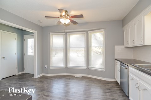 A kitchen with a ceiling fan and wooden floors.