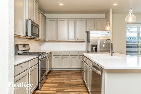 A kitchen with wooden floors and white appliances.