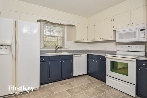 A kitchen with a white refrigerator, white microwave, and white oven.