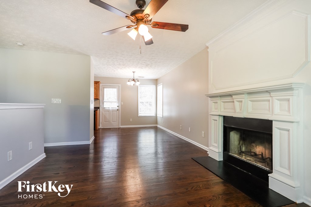 a living room with a fireplace and a ceiling fan