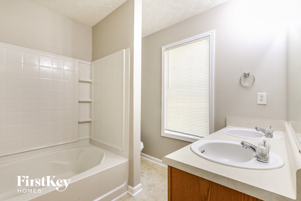 a bathroom with a tub and a sink and a mirror