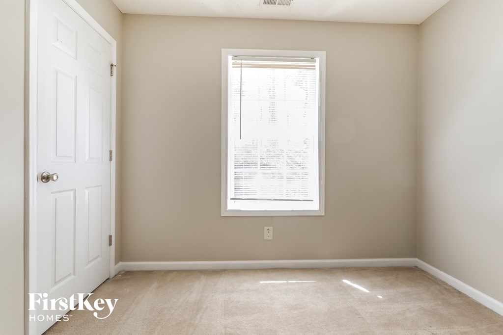 an empty room with a window and a white door