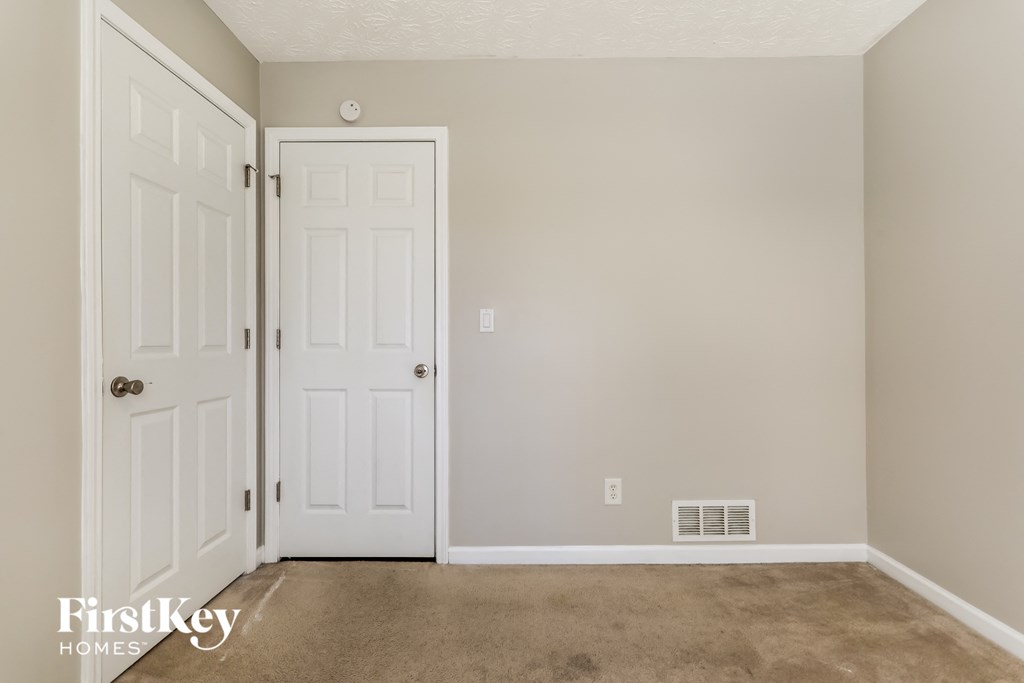 a room with a carpeted floor and a white door