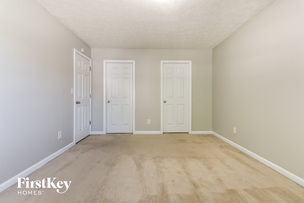 a empty room with two doors and a wooden floor