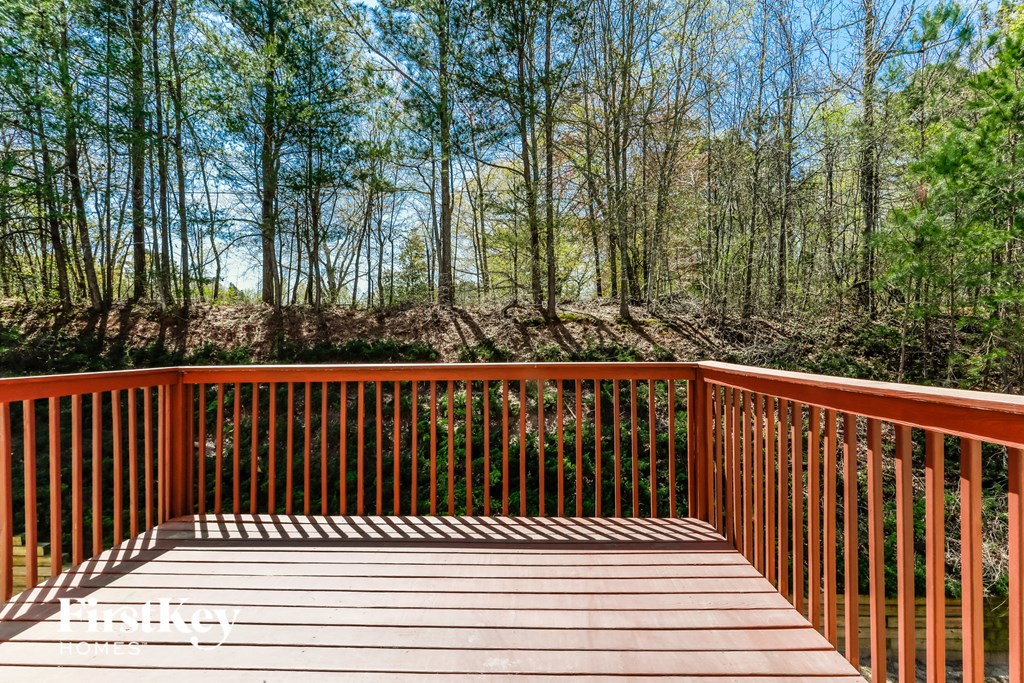 a deck with a view of the woods and a blue sky