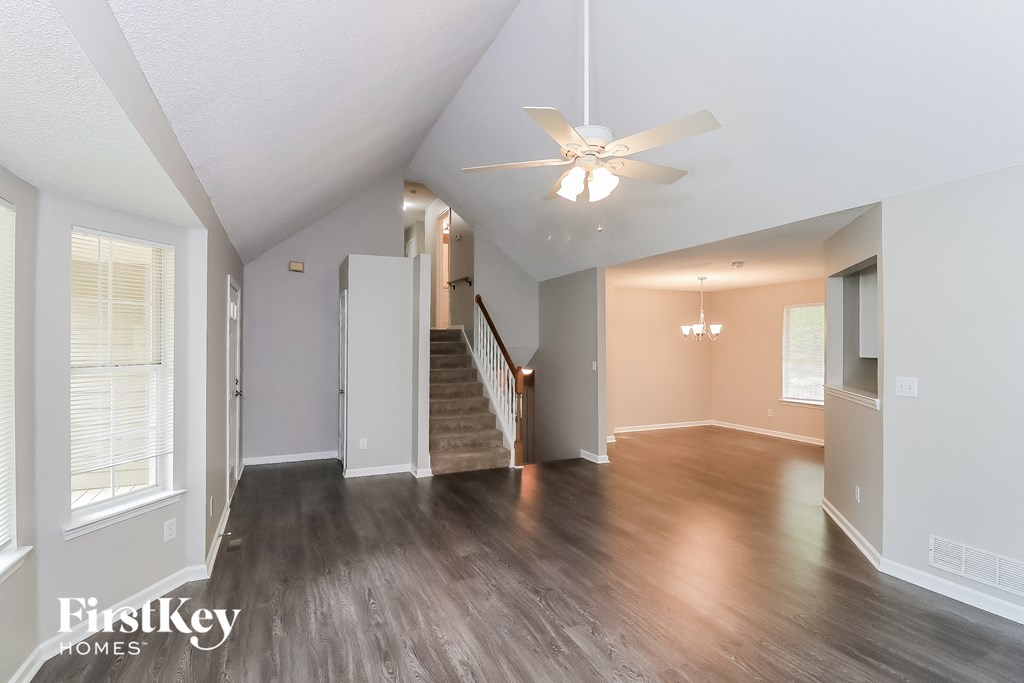 A spacious room with a staircase leading to the second floor.