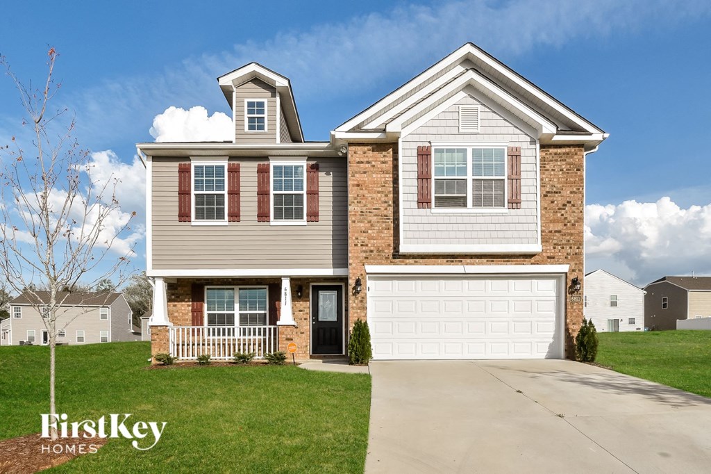 A two-story house with a garage is showcased in the image.