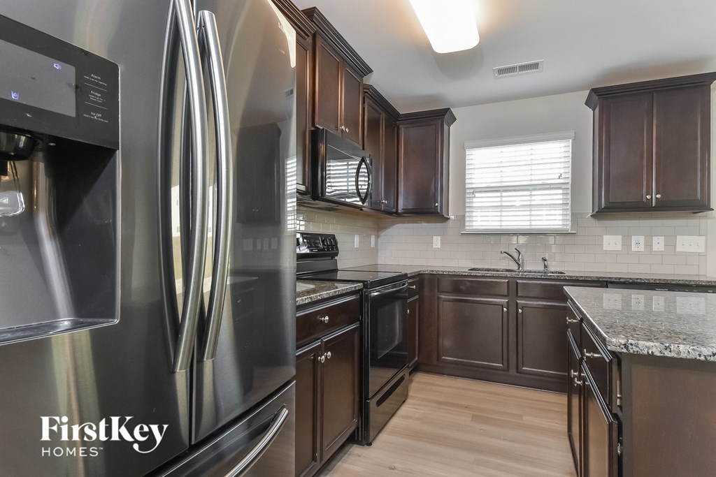 A modern kitchen with a stainless steel refrigerator and wooden cabinets.