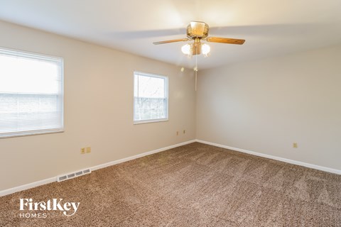 a bedroom with carpet and a ceiling fan