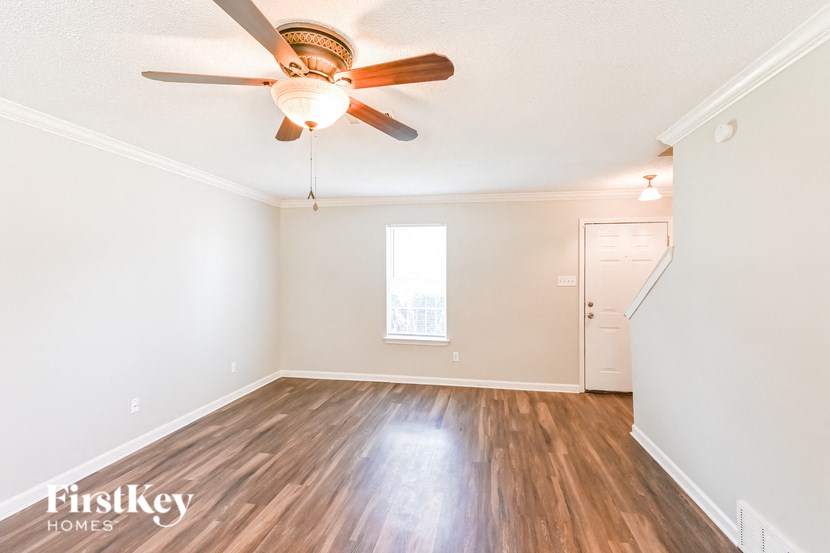 a living room with hardwood floors and a ceiling fan