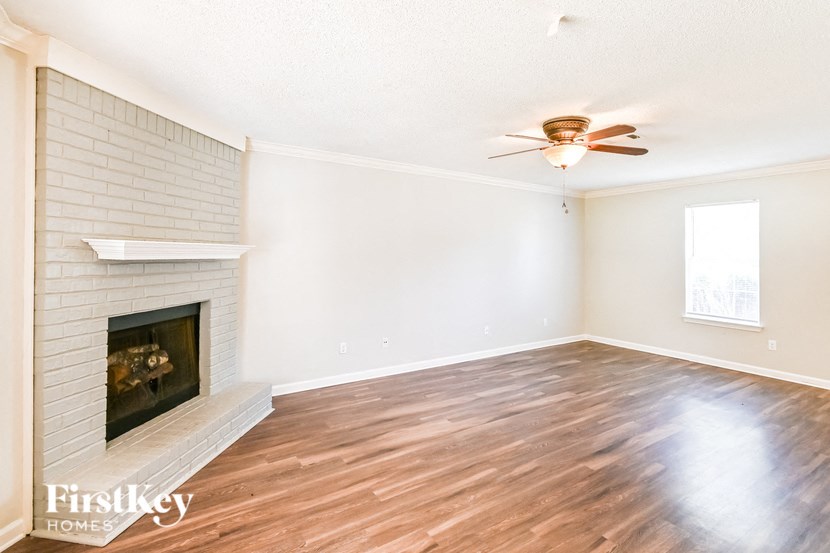 a living room with a fireplace and a ceiling fan