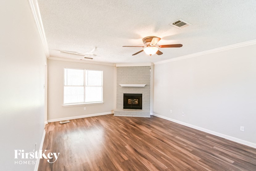 a living room with a fireplace and a ceiling fan