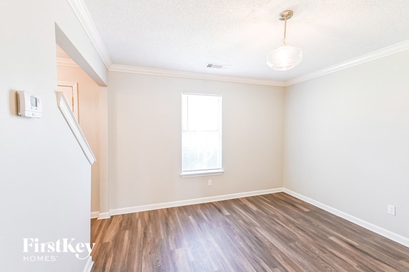 an empty living room with wood flooring and a window