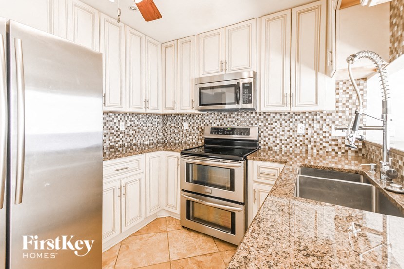 a kitchen with white cabinets and stainless steel appliances