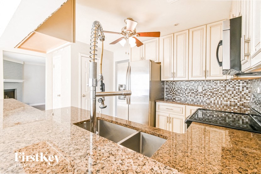 a kitchen with granite counter tops and white cabinets