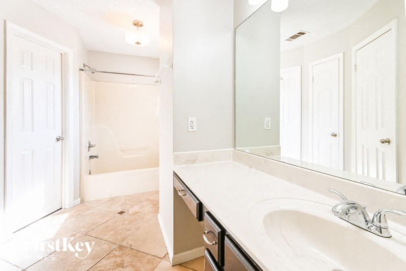 a bathroom with a sink and a mirror and a shower