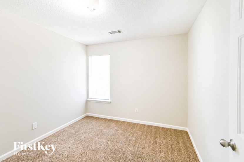 a room with a carpeted floor and a window