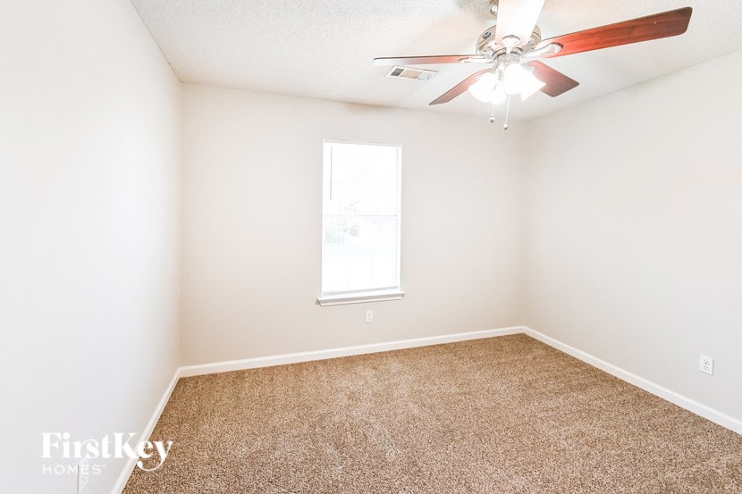 a room with carpet and a ceiling fan