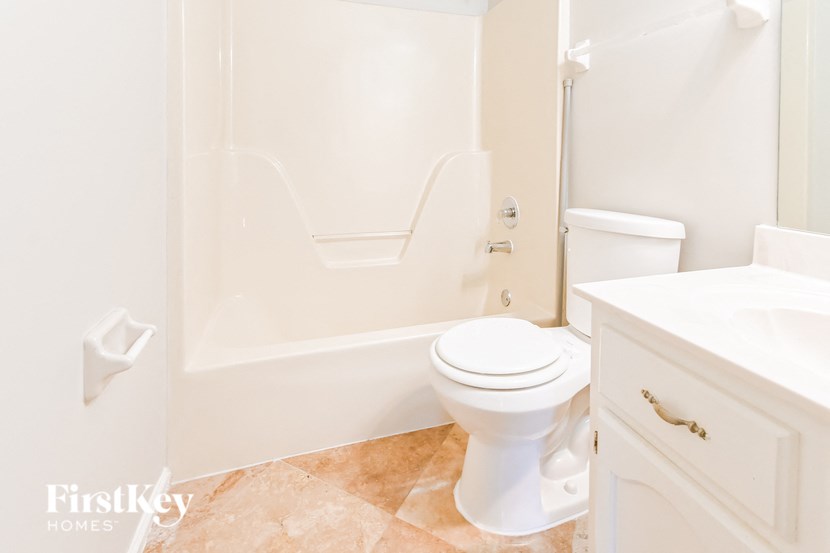 a bathroom with a toilet and a tub and a sink