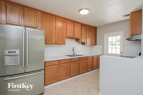 A kitchen with wooden cabinets and a stainless steel refrigerator.
