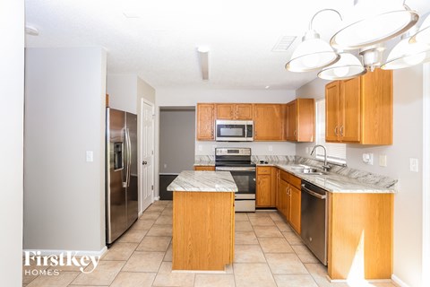 A kitchen with wooden cabinets and a marble countertop.