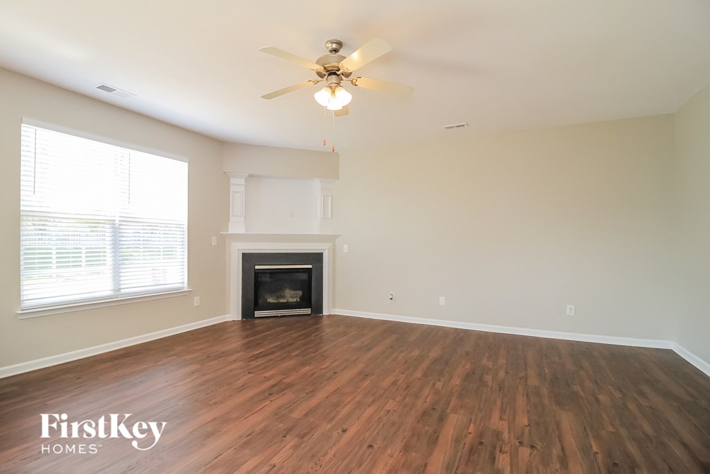 A room with a fireplace and a ceiling fan.