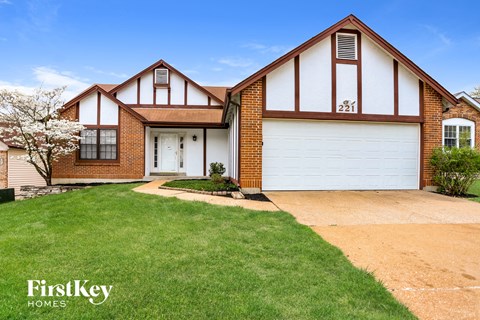 a house with a lawn and a driveway in front of it