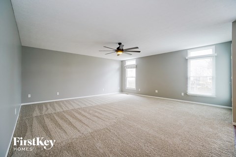 the living room of an empty house with a ceiling fan
