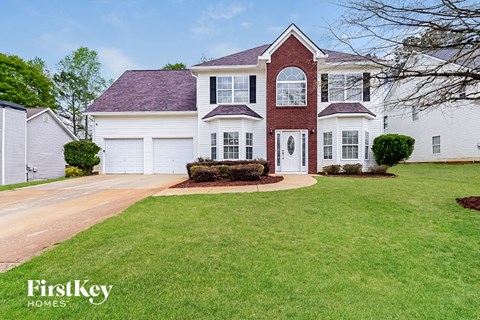 A large house with a red roof and a white garage door.