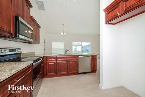 A kitchen with brown cabinets and a stove top oven.