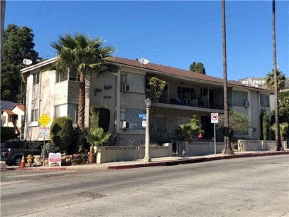 a building on the side of a street with palm trees
