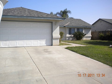 a driveway in front of a house with a white garage door