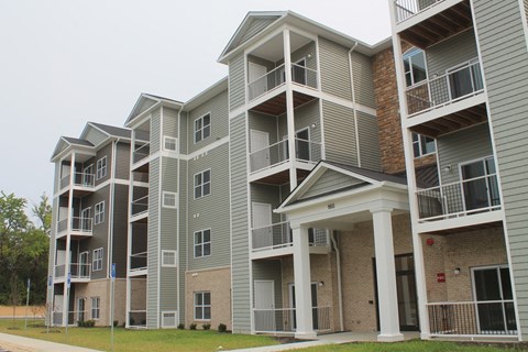 Apartment building with balconies and a covered entrance.