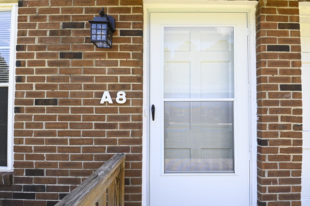 the front door of a brick house with a white door