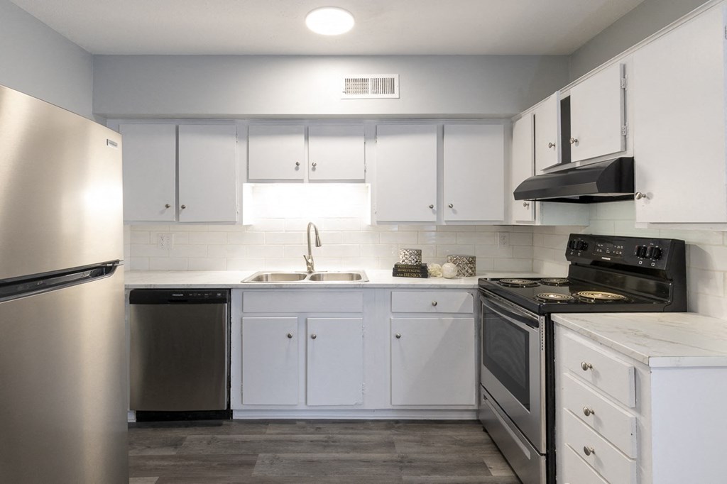 a kitchen with white cabinets and stainless steel appliances