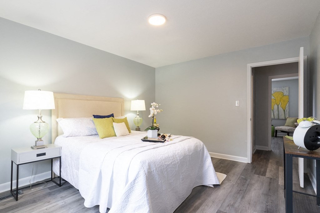 a bedroom with a bed and a door to a living room