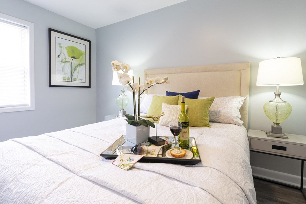 a tray with wine and flowers on a bed