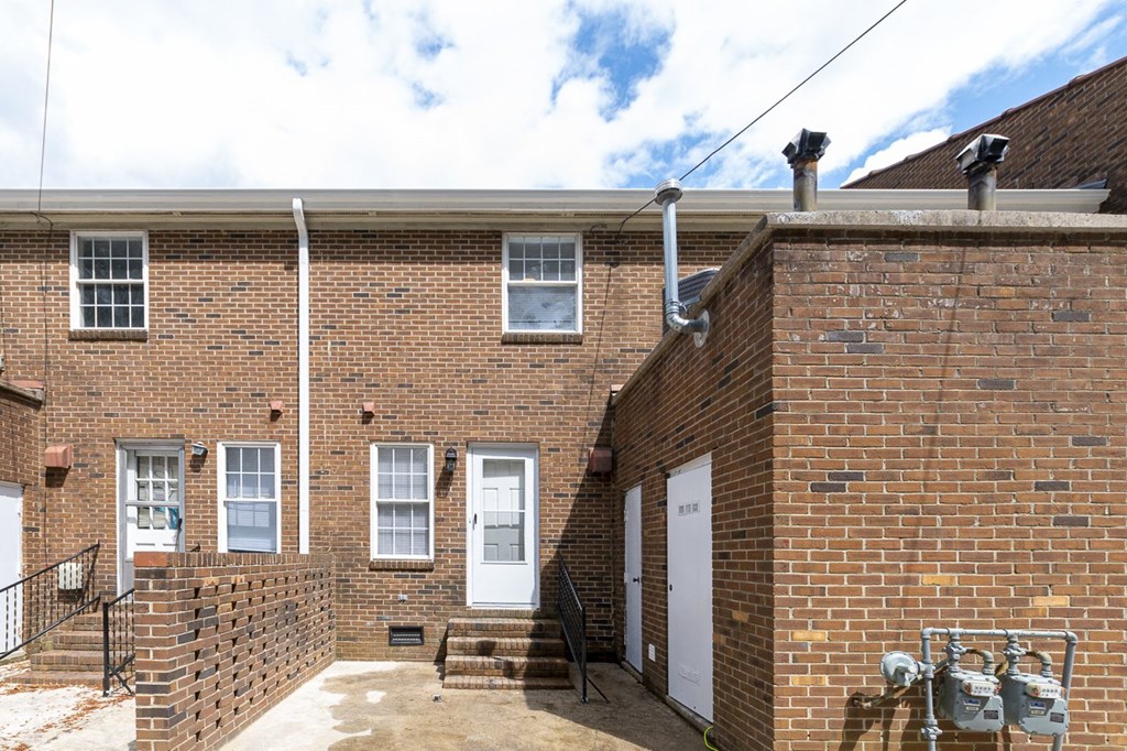 the front of a brick building with a white door