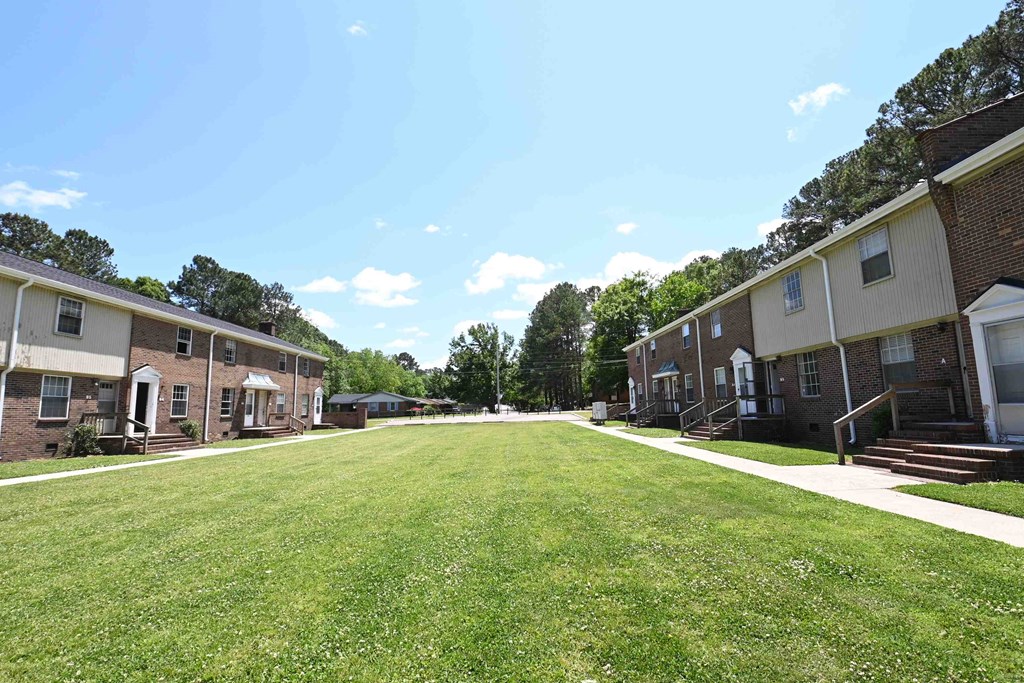 a large lawn in front of a row of houses
