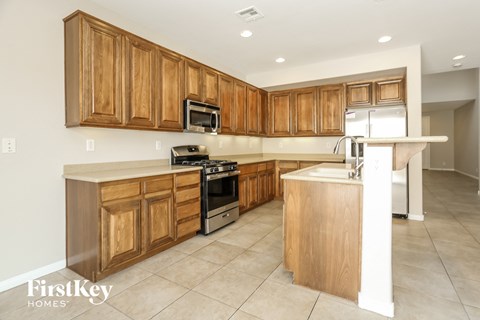 A kitchen with wooden cabinets and a white island.
