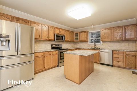 A kitchen with wooden cabinets and a stainless steel refrigerator.