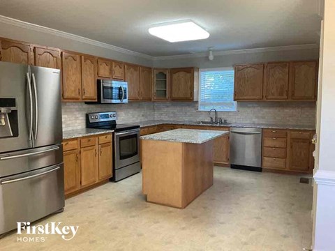 A kitchen with wooden cabinets and a stainless steel refrigerator.