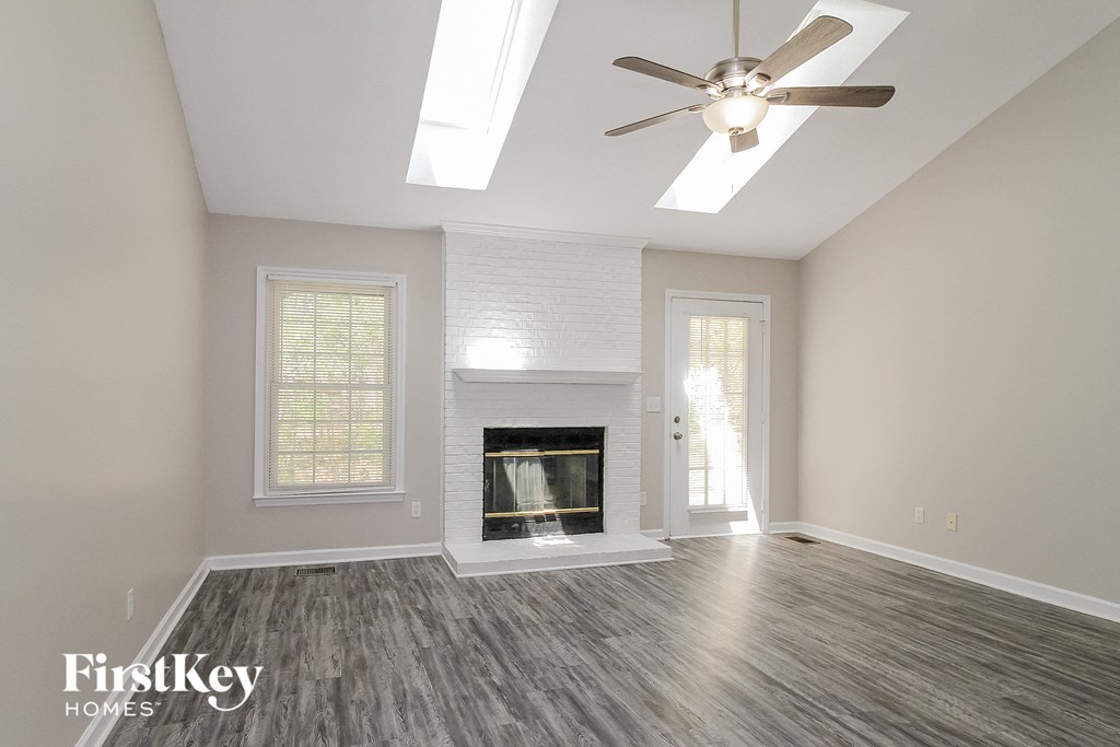 a living room with a fireplace and a ceiling fan