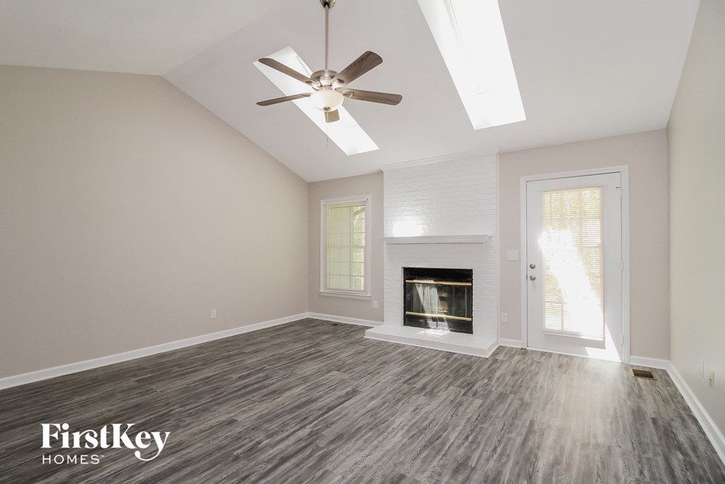 the living room with fireplace and ceiling fan