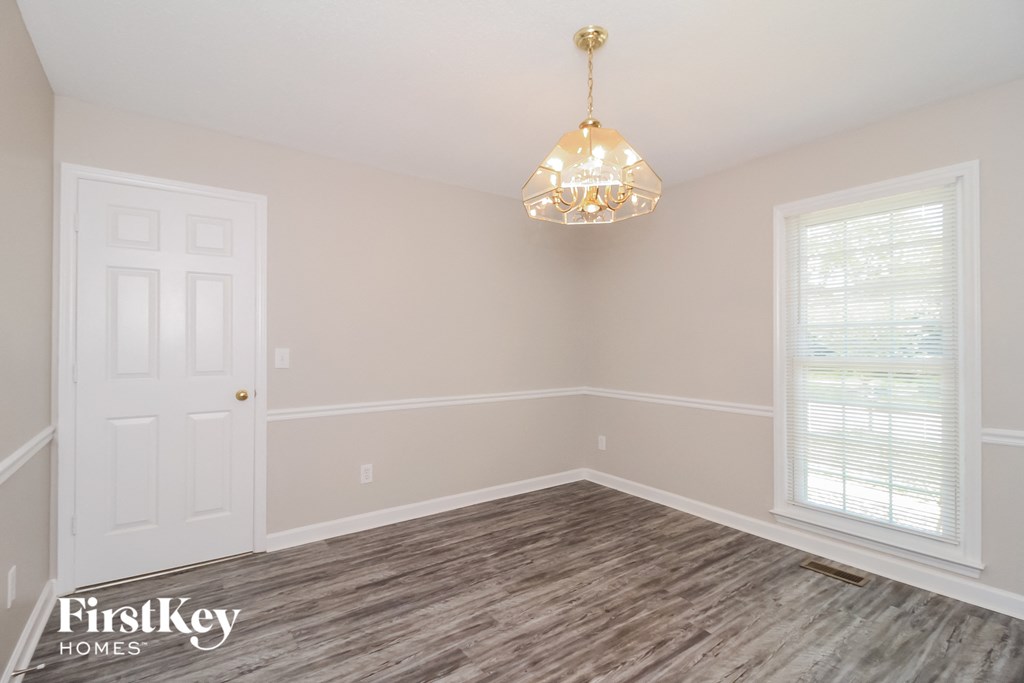 the living room of a home with wood floors and a chandelier